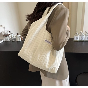 Detail der cremefarbenen Falten-Stofftasche mit KISS YOURSELF Label im Café-Ambiente