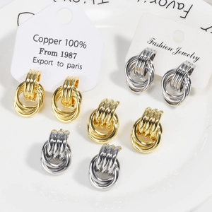 Three-layer twisted knot hoop earrings in gold and silver finish shown on display cards