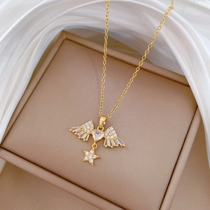 Detailed macro view of a gold titanium star and wing heart pendant on white silk fabric