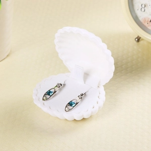 Boîte à bijoux coquillage blanc avec boucles d'oreilles en cristal bleu sur velours