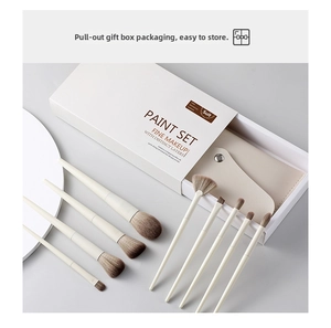 Detail of 8-piece makeup brush set with elegant cream handles and leather storage pouch