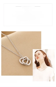 Detail of interlocking heart pendant with zircon inlay on S925 sterling silver chain
