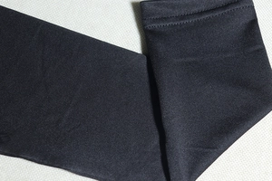 Macro detail showing fine stitching and elastic fabric texture of a black long-sleeve dress