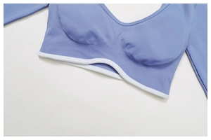 Detail of light blue ribbed yoga top featuring white wave-edge hem and built-in cups
