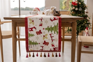 Detailed view of Christmas table runner with tassels on a wooden dining table
