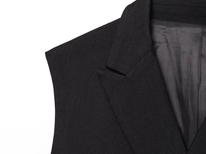 Detail of classic black notched lapel and shoulder tailoring on sleeveless vest