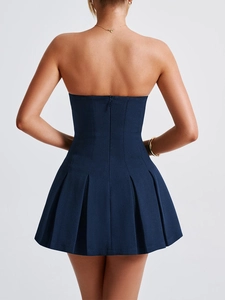 Detail view of the back of a navy blue strapless pleated dress with a hidden zipper