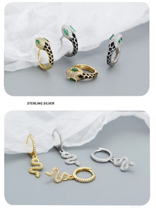 Detail of s925 sterling silver snake earrings with green eyes and black enamel finish