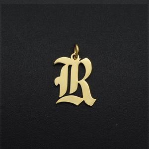 Close-up of a gold-plated Gothic letter R pendant in stainless steel for DIY jewelry