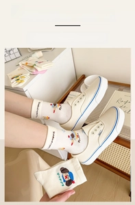 Close-up of high-elasticity cuffs on cream mid-calf socks with cute puppy patterns