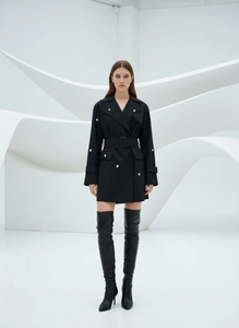Détail d'une robe blazer noire cintrée chic avec boucle en métal et revers élégants
