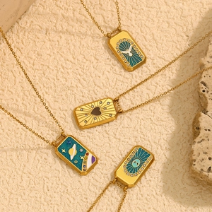 Détail de pendentifs tarot avec motifs pigeon, cœur, planète et œil en émail