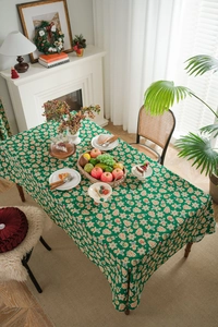 Close-up of green cotton linen tablecloth with Christmas gingerbread man and snowflake pattern