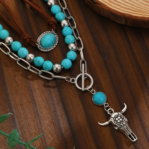 Detail van boho gelaagde ketting met turkoois kralen en zilveren stierenschedel hanger