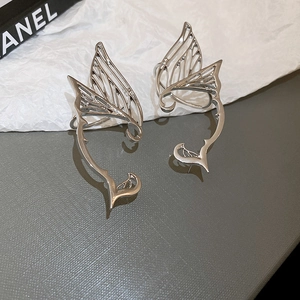 Detailed close-up of silver butterfly wing ear cuffs with hollow metallic design