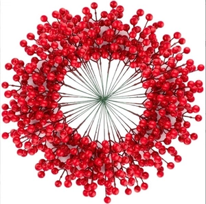 Macro shot of vibrant red artificial holly berries arranged in a circular wreath design