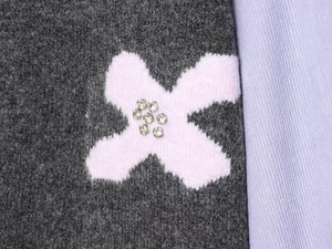 Détail du motif étoile jacquard rose avec strass argentés sur le cardigan gris tricoté