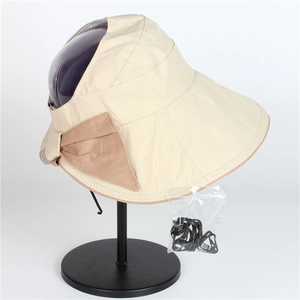 Beige wide brim sun visor hat with bow and windproof cord on a minimalist display