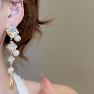Detail of luxury drop earring with sparkling crystals and elegant white pearls