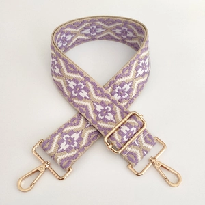 Close-up of jacquard woven strap with purple ethnic pattern and gold metal buckles