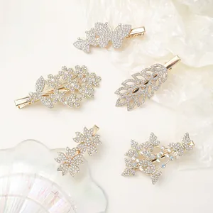 Detail view of five gold rhinestone hair clips set featuring butterfly and floral patterns