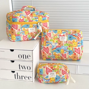 Three-piece quilted makeup bag set with colorful cartoon patterns and yellow zippers
