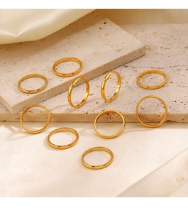 Set of ten minimalist golden stainless steel rings on premium silk and stone background