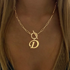 Detail view of a gold initial D pendant necklace with a stylish T-bar toggle clasp