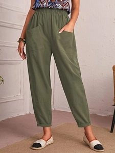 Detail of high-waist elastic waistband and large side pockets on linen cropped pants