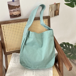 Dettaglio di borsa tote in tela verde menta su sedia in legno vintage