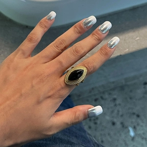 Detailed close-up of 18k gold-plated ring featuring a large black onyx stone inlay