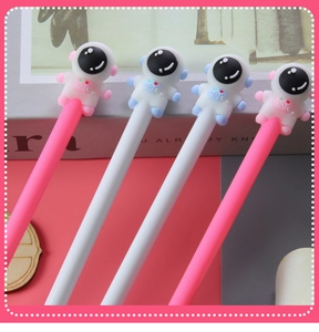 Close-up of pink and white astronaut pens with soft silicone cartoon space figures