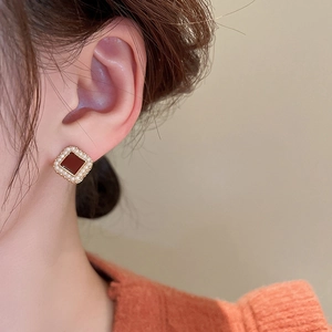 Vue détaillée de boucles d'oreilles vintage avec pierre rouge et perles sur un mannequin