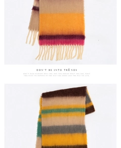 Detailed close-up of soft multi-color striped scarf fabric with fringe tassels