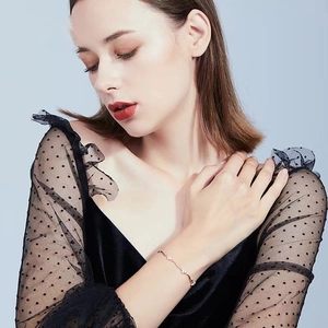 Minimalist lucky four-leaf clover bracelet in rose gold finish on model's wrist