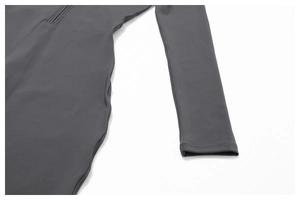 Detail of dark grey fleece-lined yoga jumpsuit featuring a high-neck half-zipper design