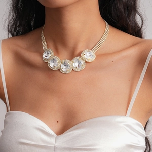 Close-up of sparkling gold choker with five large crystals on elegant white satin