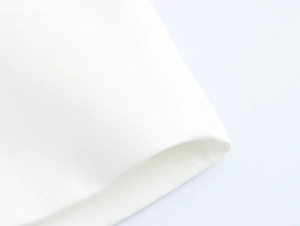 Detailed close-up of premium white woven fabric texture for a structured blazer