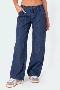 Détail d'un jean cargo ample avec coutures contrastées jaunes et empiècements aux genoux