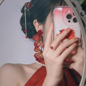 Detailed view of red rose earrings and floral accessories for a vintage look