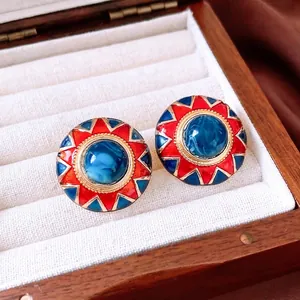 Vintage gold-rimmed geometric resin stud earrings with marble effect center
