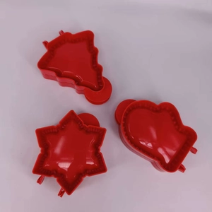 Detailed view of red 3D Christmas tree snowflake and heart shaped plastic baking cutters