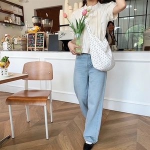 Detailed shot of a large capacity white polka dot canvas shoulder bag for daily use