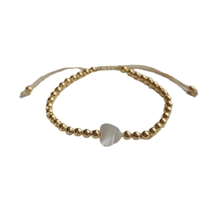Adjustable golden beaded bracelet featuring a white iridescent shell heart charm