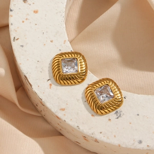 Macro view of 18K gold plated square earrings with spiral texture and clear zircon