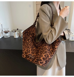 Close-up of leopard print tote bag featuring dark brown leather straps and canvas texture