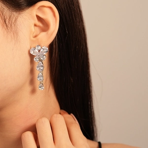 Close-up of elegant zircon butterfly drop earrings with pear-cut crystal tassels on a model