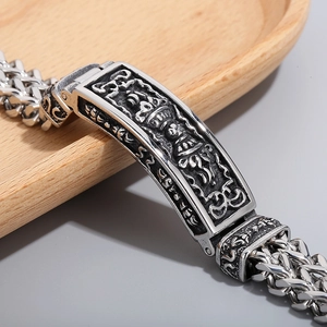 Macro shot of titanium steel men's bracelet with vintage totem engraving and weave chain