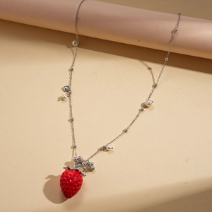 Close-up of a red strawberry pendant with resin texture and white pearls on a silver chain