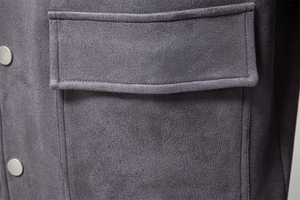 Détail de la veste en daim gris foncé avec poche plaquée et boutons-pression métalliques